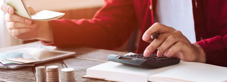 Person doing calculations with coins and calculator