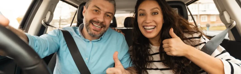 Happy couple driving in car